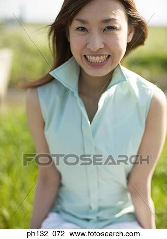 Young woman smiling outdoors View Large Photo Image Stock Image - Young woman smiling outdoors. Fotosearch