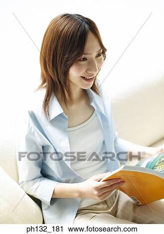 Young woman smiling with book in hand View Large Photo Image Stock Image - Young woman smiling with book in hand. Fotosearch