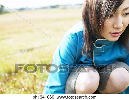 Young woman squatting View Large Photo Image Stock Photograph - Young woman squatting. Fotosearch