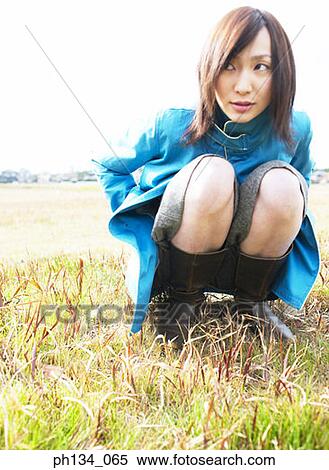 Stock Photography - Young woman squatting. Fotosearch