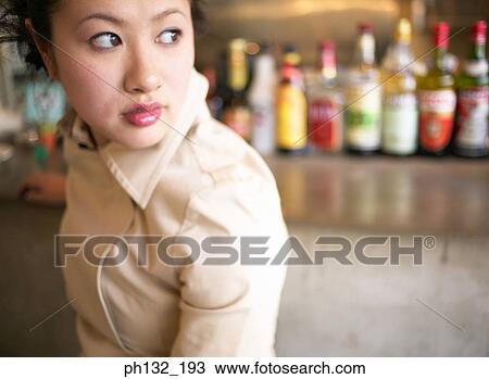 Stock Image - Young woman waiting in a bar. Fotosearch