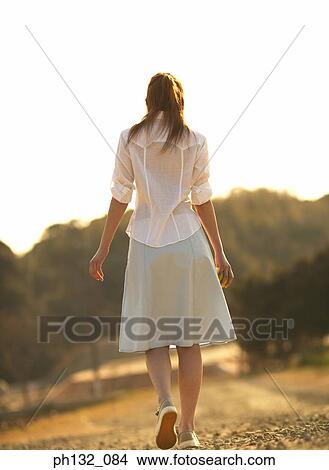 Picture - Young woman walking alone. Fotosearch