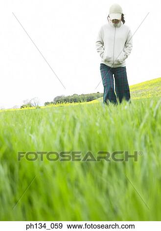 Stock Photo - Young woman walking in field. Fotosearch