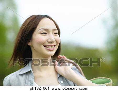 Young woman with a bag smiling View Large Photo Image Stock Image - Young woman with a bag smiling. Fotosearch