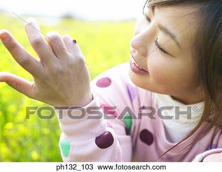 Young woman with a lady bird on her hand View Large Photo Image Stock Image - Young woman with a lady bird on her hand. Fotosearch