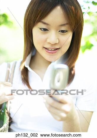 Stock Image - Young woman with mobile phone. Fotosearch