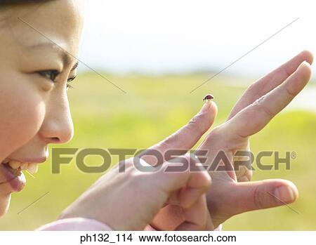 Young women holding a lady bird on finger View Large Photo Image Picture - Young women holding a lady bird on finger. Fotosearch