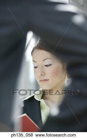A young businesswoman standing across a man View Large Photo Image Stock Photo - A young businesswoman standing across a man. Fotosearch