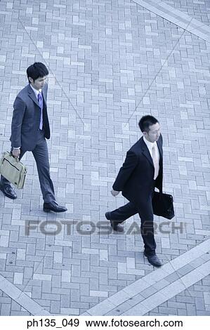 High angle view of two young businessmen walking outdoors View Large Photo Image Stock Photo - High angle view of two young businessmen walking outdoors. Fotosearch