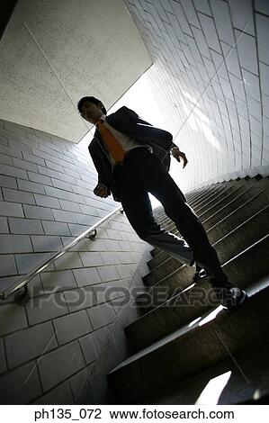Low angle view of a young businessman coming down a flight of stairs View Large Photo Image Stock Image - Low angle view of a young businessman coming down a flight of stairs. Fotosearch