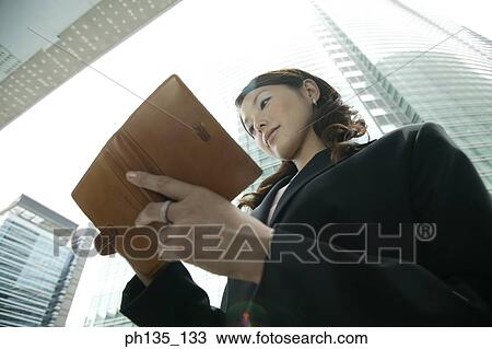 Low angle view of a young businesswoman writing in a diary View Large Photo Image Stock Image - Low angle view of a young businesswoman writing in a diary. Fotosearch
