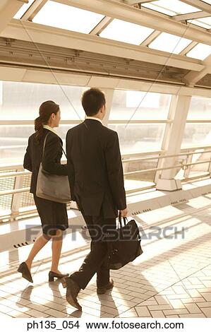 Rear view of two executives walking in a passageway View Large Photo Image Picture - Rear view of two executives walking in a passageway. Fotosearch