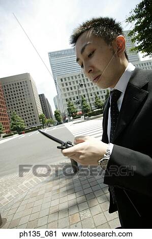 Side profile of a young businessman using a mobile phone View Large Photo Image Stock Image - Side profile of a young businessman using a mobile phone. Fotosearch