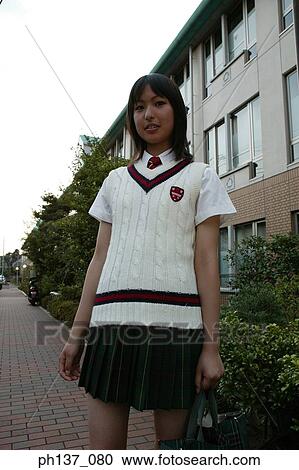 Stock Image - Teenage girl standing outdoors. Fotosearch
