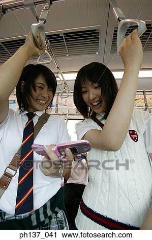 Teenage girls standing in a train View Large Photo Image Stock Image - Teenage girls standing in a train. Fotosearch