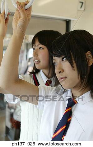 Teenage girls standing in a train View Large Photo Image Stock Photograph - Teenage girls standing in a train. Fotosearch