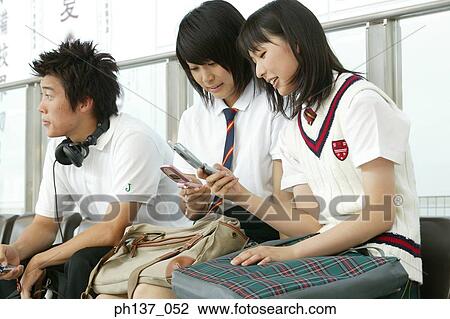 Teenager sitting together operating mobile phones View Large Photo Image Stock Image - Teenager sitting together operating mobile phones. Fotosearch