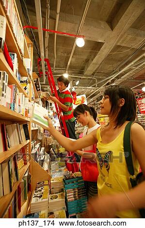 Teenagers looking at books in a store View Large Photo Image Picture - Teenagers looking at books in a store. Fotosearch
