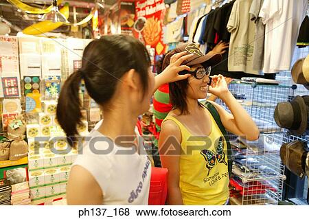Teenagers looking at hats in a store View Large Photo Image Stock Photo - Teenagers looking at hats in a store. Fotosearch