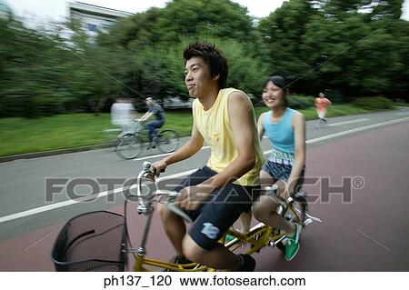 Teenagers riding a tandem bicycle View Large Photo Image Stock Image - Teenagers riding a tandem bicycle. Fotosearch