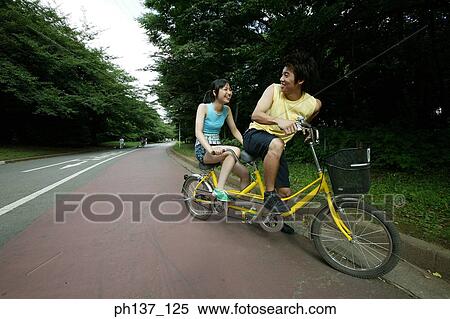Teenagers riding a tandem bicycle View Large Photo Image Stock Photography - Teenagers riding a tandem bicycle. Fotosearch