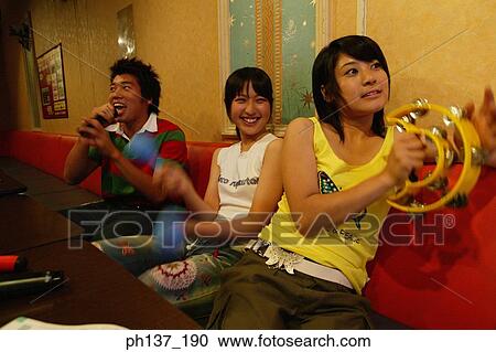 Teenagers singing at a karaoke bar View Large Photo Image Stock Image - Teenagers singing at a karaoke bar. Fotosearch