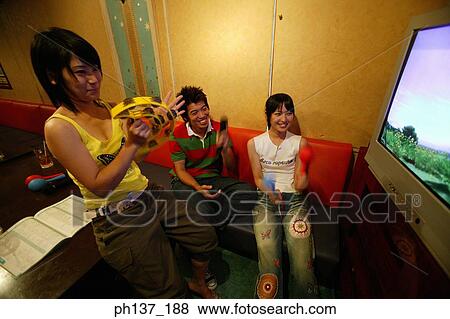 Teenagers singing at a karaoke bar View Large Photo Image Stock Photo - Teenagers singing at a karaoke bar. Fotosearch