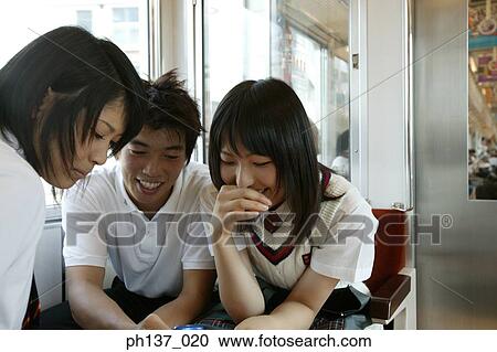 Teenagers sitting in a train talking View Large Photo Image Stock Image - Teenagers sitting in a train talking. Fotosearch