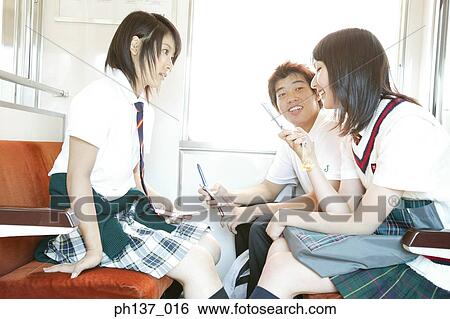 Stock Photograph - Teenagers sitting in a train talking. Fotosearch