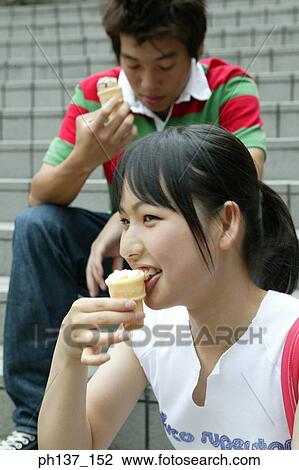 Teenagers sitting together eating ice cream View Large Photo Image Stock Image - Teenagers sitting together eating ice cream. Fotosearch