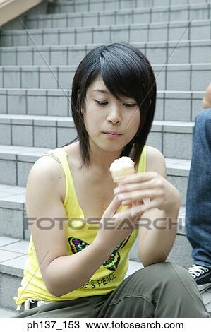 Teenagers sitting together eating ice cream View Large Photo Image Stock Image - Teenagers sitting together eating ice cream. Fotosearch