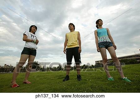Teenagers standing on a lawn View Large Photo Image Picture - Teenagers standing on a lawn. Fotosearch