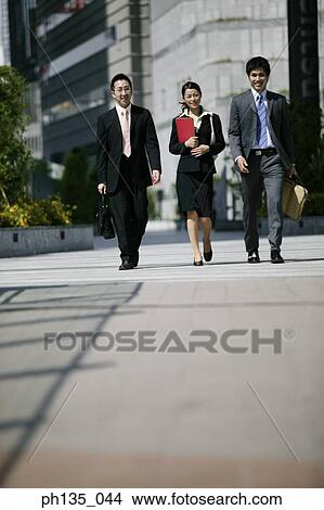 Three executives crossing a street View Large Photo Image Picture - Three executives crossing a street. Fotosearch