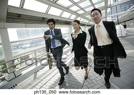 Three executives running in a passageway View Large Photo Image Stock Image - Three executives running in a passageway. Fotosearch