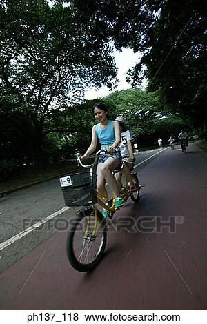 Two Teenage girls riding a tandem bicycle View Large Photo Image Stock Photo - Two Teenage girls riding a tandem bicycle. Fotosearch