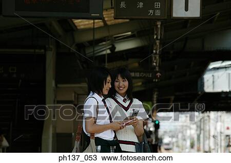 Two teenage girls standing at a train station View Large Photo Image Stock Image - Two teenage girls standing at a train station. Fotosearch