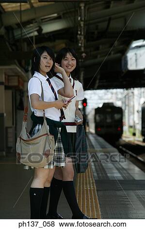 Two teenage girls standing at a train station View Large Photo Image Stock Photo - Two teenage girls standing at a train station. Fotosearch