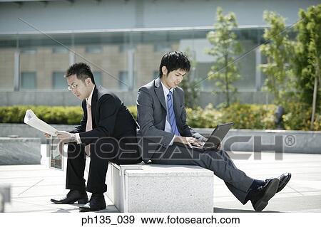 Two young businessmen working outdoors View Large Photo Image Stock Photo - Two young businessmen working outdoors. Fotosearch