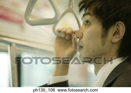 Young businessman holding a safety handle View Large Photo Image Stock Photograph - Young businessman holding a safety handle. Fotosearch