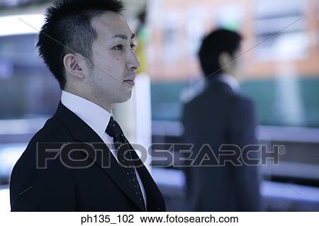 Stock Image - Young businessman looking ahead. Fotosearch