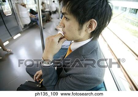 Stock Photo - Young businessman sitting in a train. Fotosearch