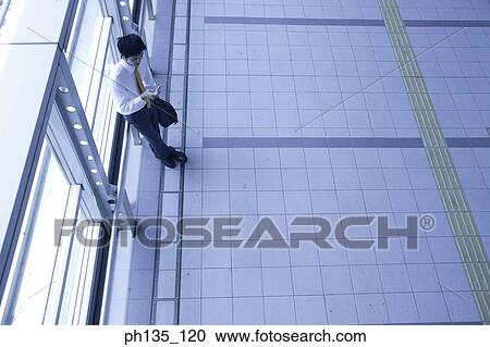 Young businessman standing Indoors View Large Photo Image Stock Image - Young businessman standing Indoors. Fotosearch