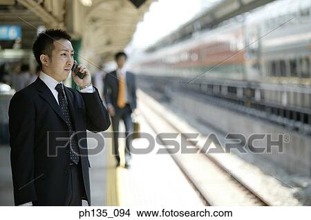 Young businessman talking on a mobile phone View Large Photo Image Picture - Young businessman talking on a mobile phone. Fotosearch