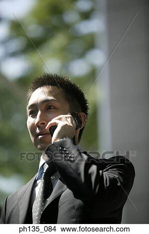 Young businessman using a mobile phone View Large Photo Image Picture - Young businessman using a mobile phone. Fotosearch
