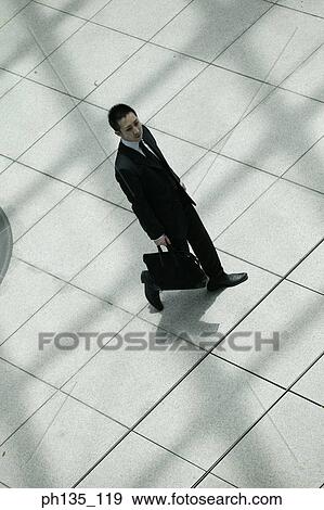 Stock Photo - Young businessman walking with a briefcase. Fotosearch