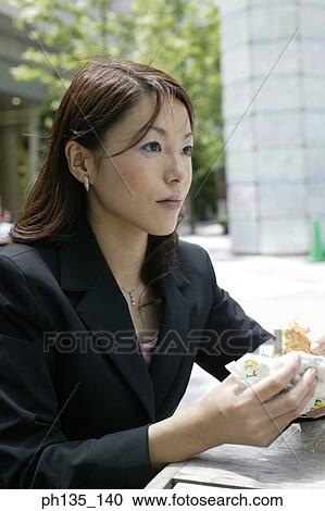 Young businesswoman holding a sandwich View Large Photo Image Stock Image - Young businesswoman holding a sandwich. Fotosearch