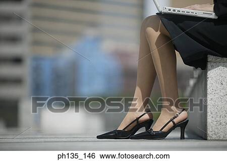 Young businesswoman operating a laptop computer View Large Photo Image Stock Photograph - Young businesswoman operating a laptop computer. Fotosearch