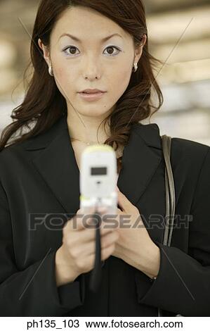 Young businesswoman operating a mobile phone View Large Photo Image Stock Image - Young businesswoman operating a mobile phone. Fotosearch