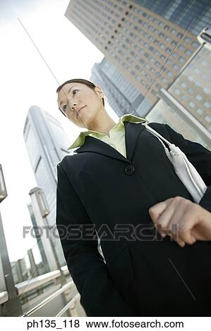 Stock Photo - Young businesswoman standing outdoors. Fotosearch