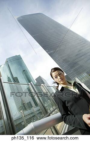 Stock Photograph - Young businesswoman standing outdoors. Fotosearch